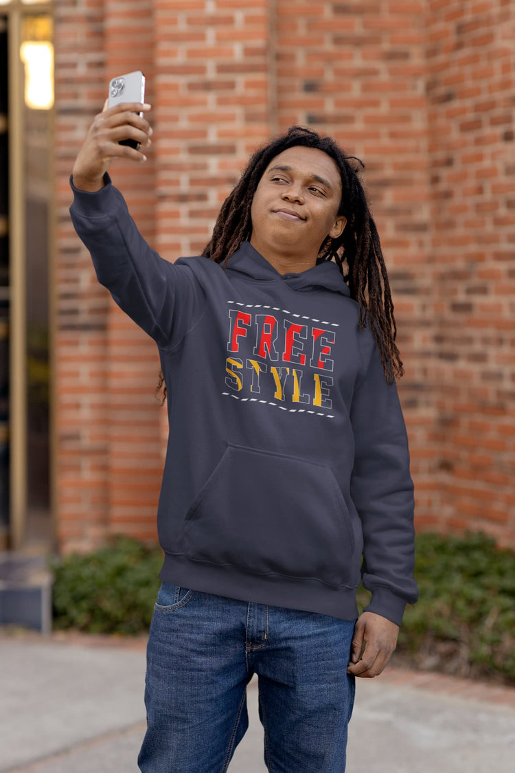 Person wearing a navy hoodie with colorful text, taking a selfie outdoors.