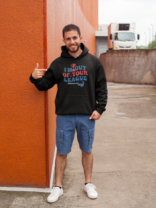 Man wearing a black hoodie with colorful text and blue shorts standing against an orange wall.