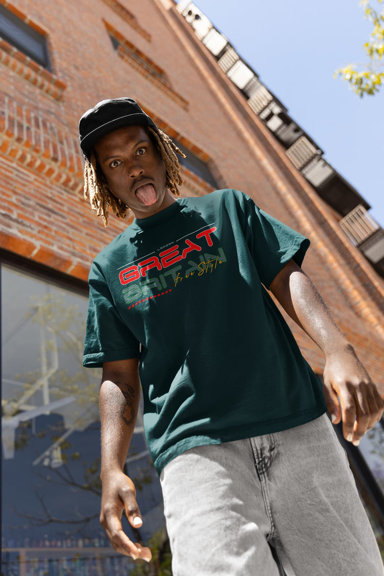 Person wearing a green t-shirt with red text, standing in front of a brick building.
