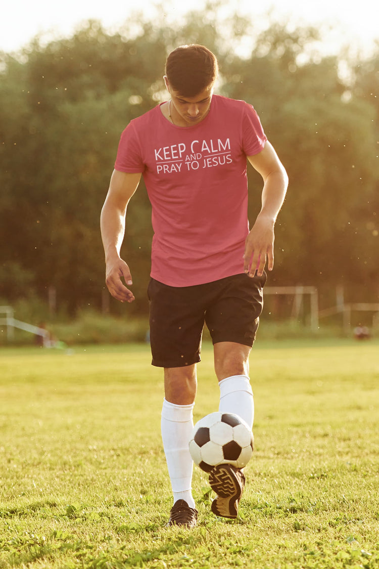 Man in pink shirt with text on a soccer field