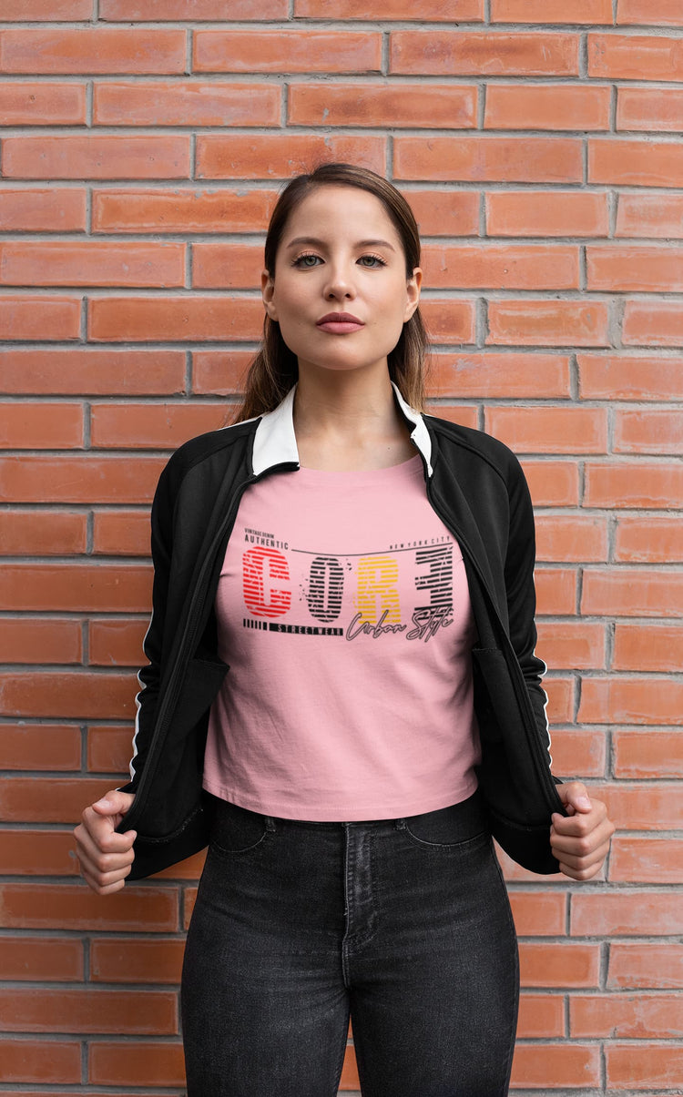 Woman wearing a pink graphic t-shirt with text against a brick wall