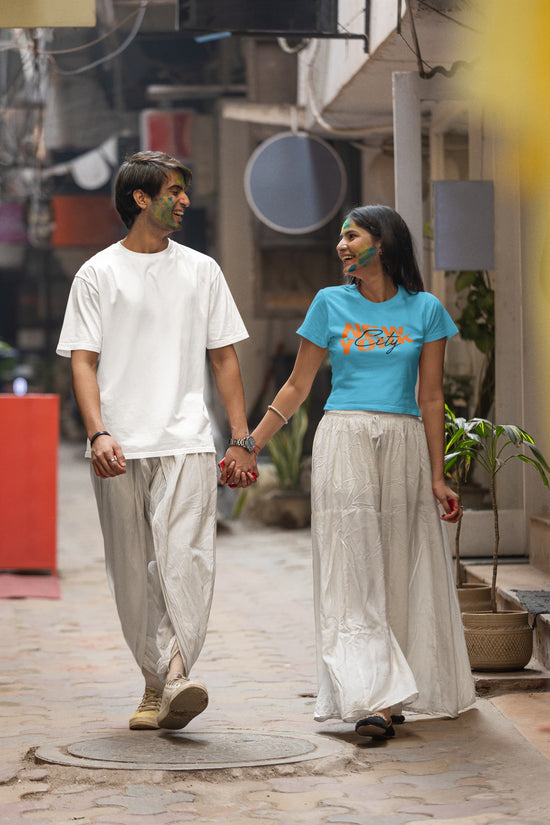 Two people holding hands on a street with a casual, urban background.
