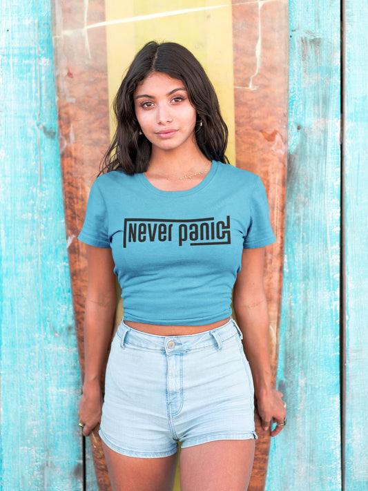 Woman wearing a blue t-shirt with 'Never panic' text against a wooden background