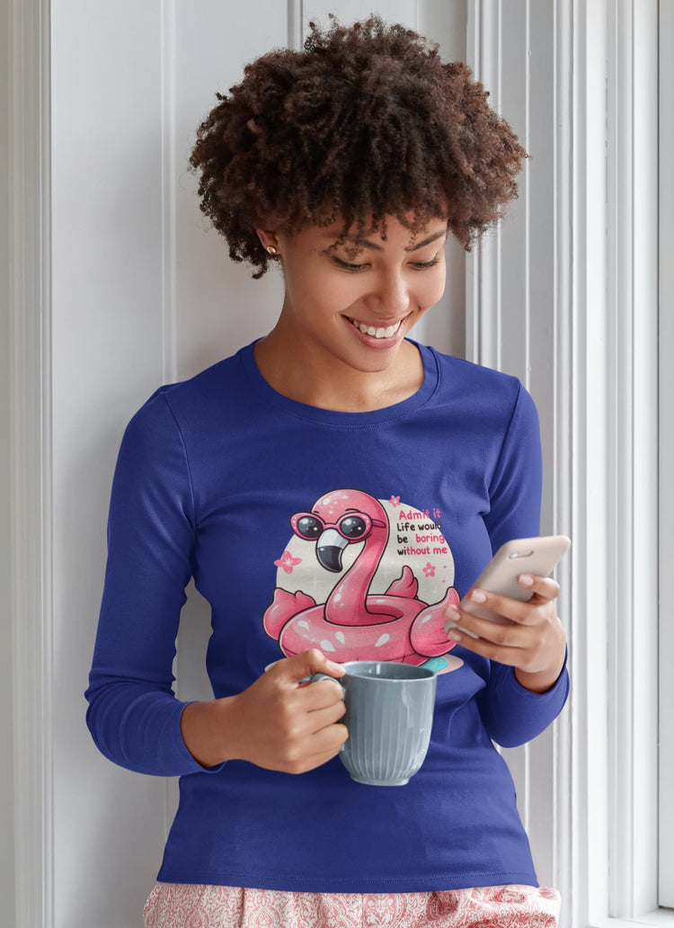 Person wearing a blue shirt with a flamingo graphic, holding a mug and phone.