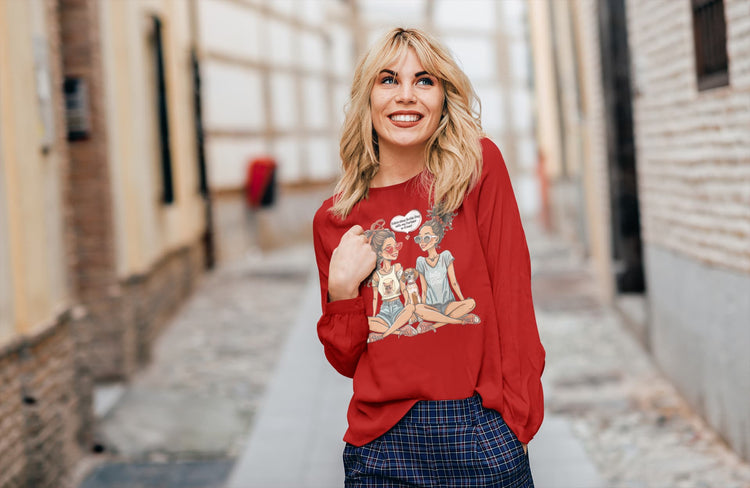 Woman wearing a red sweatshirt with graphic design, standing in an urban setting.