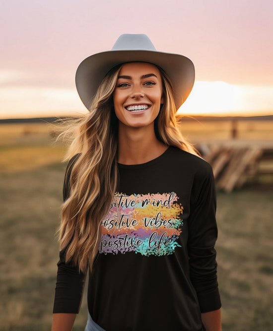 Woman wearing a black shirt with colorful text at sunset