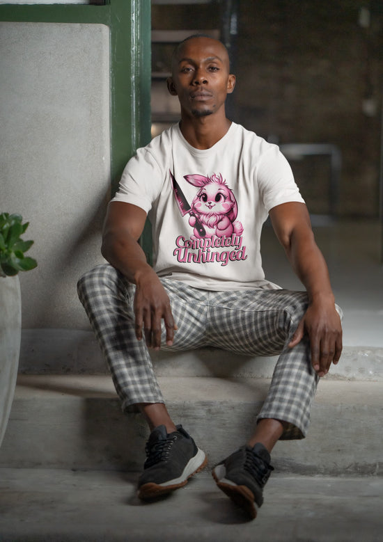 Man wearing a white t-shirt with a graphic design sitting on a bench.