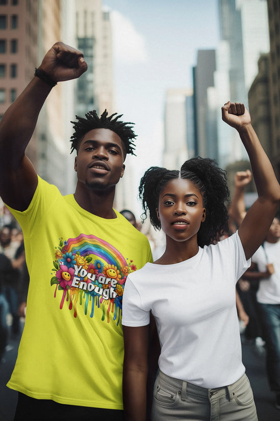 Two people raising their fists in a protest or rally setting with city buildings in the background.
