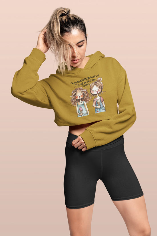 Woman wearing a mustard yellow hoodie with graphic design on a beige background