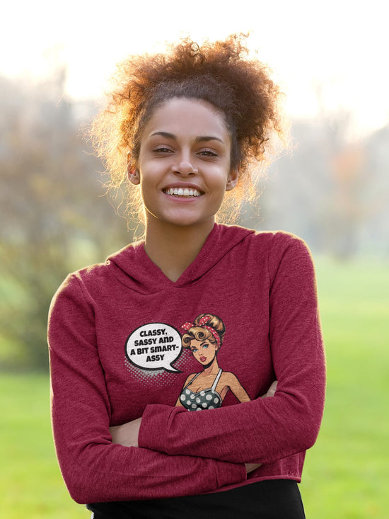 Woman wearing a maroon hoodie with a graphic design outdoors