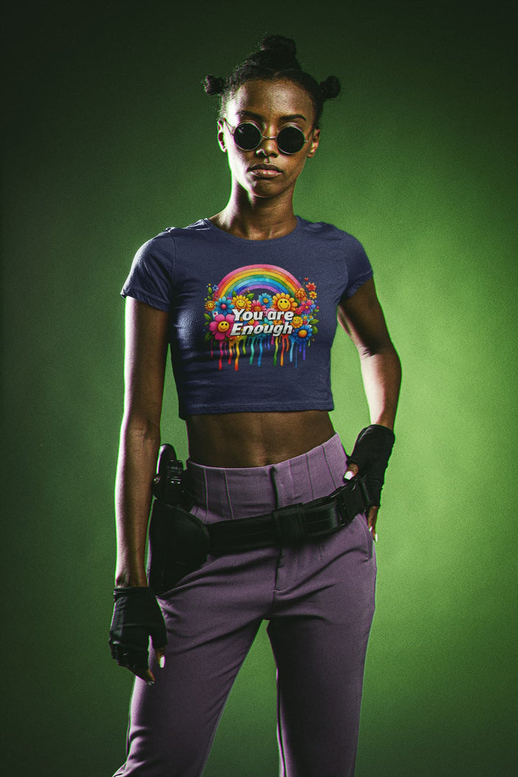 Person wearing a blue t-shirt with a rainbow design and text, standing against a green background
