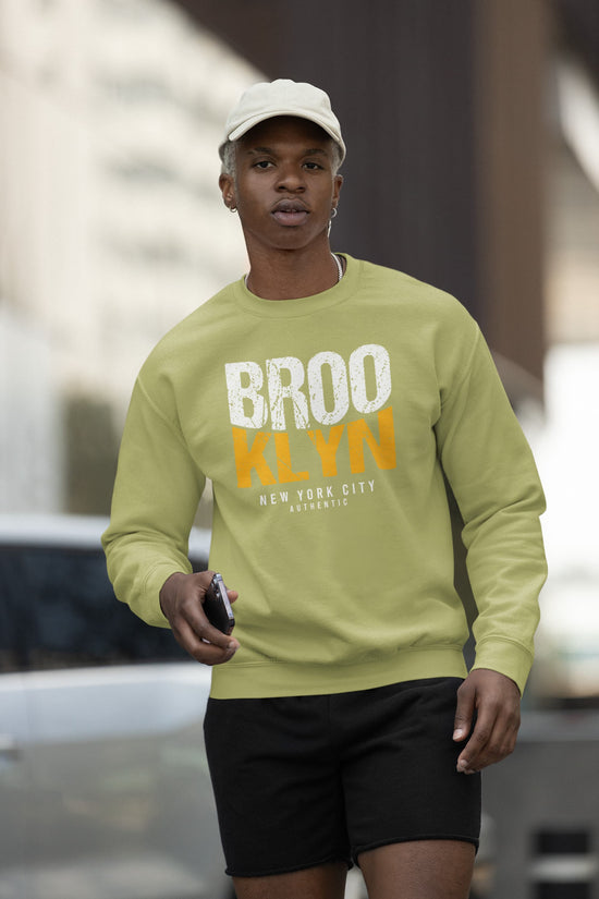 Person wearing a light green sweatshirt with &