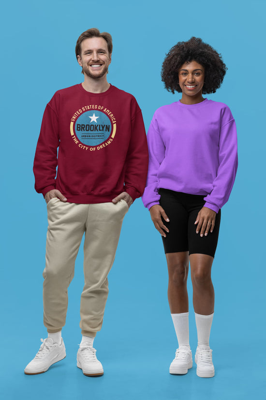 Two people wearing sweatshirts against a blue background