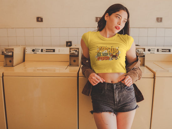 Woman in yellow t-shirt with graphic design standing in a laundry room.
