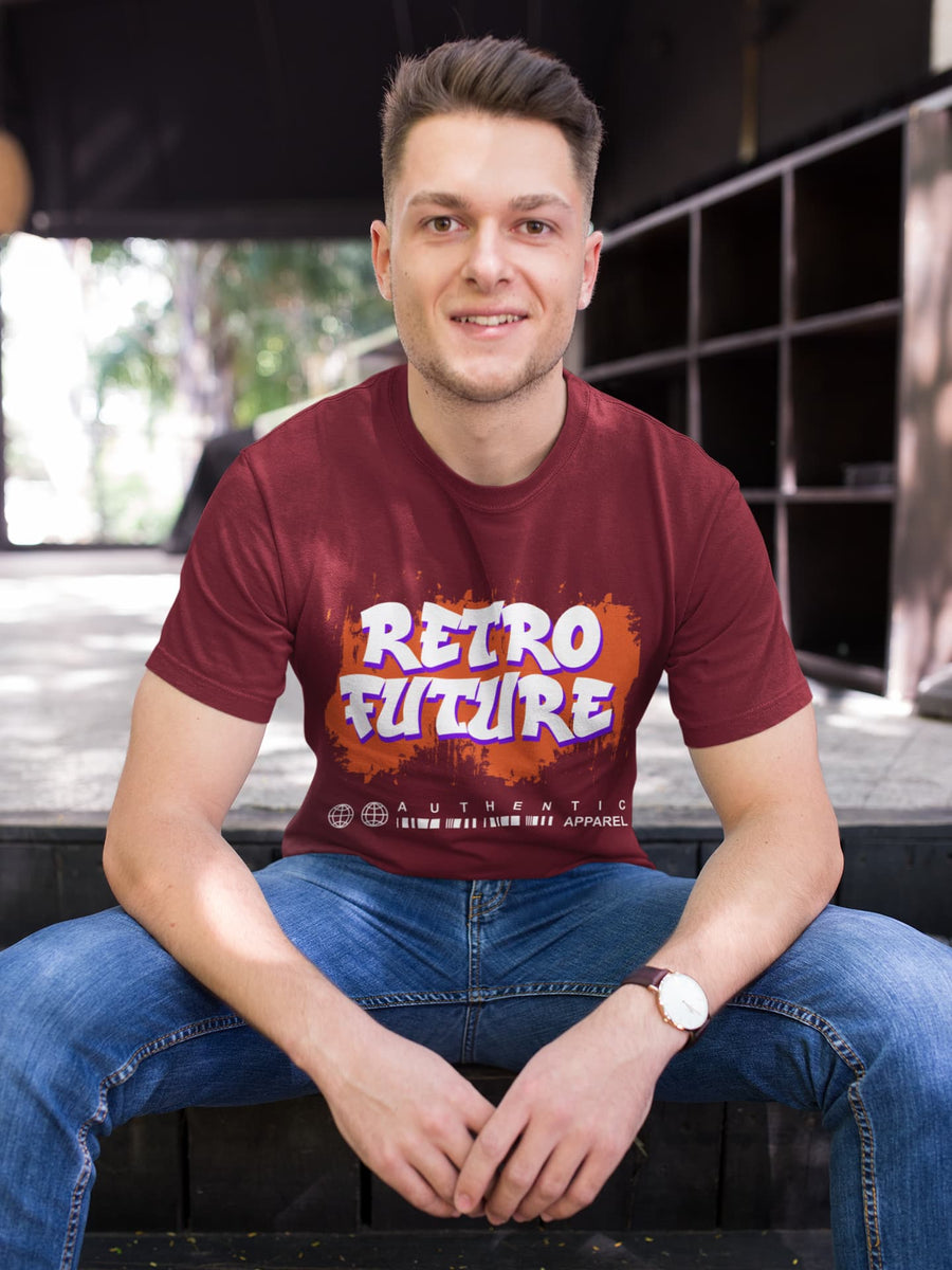 Man wearing a maroon t-shirt with 'Retro Future' design sitting outdoors.