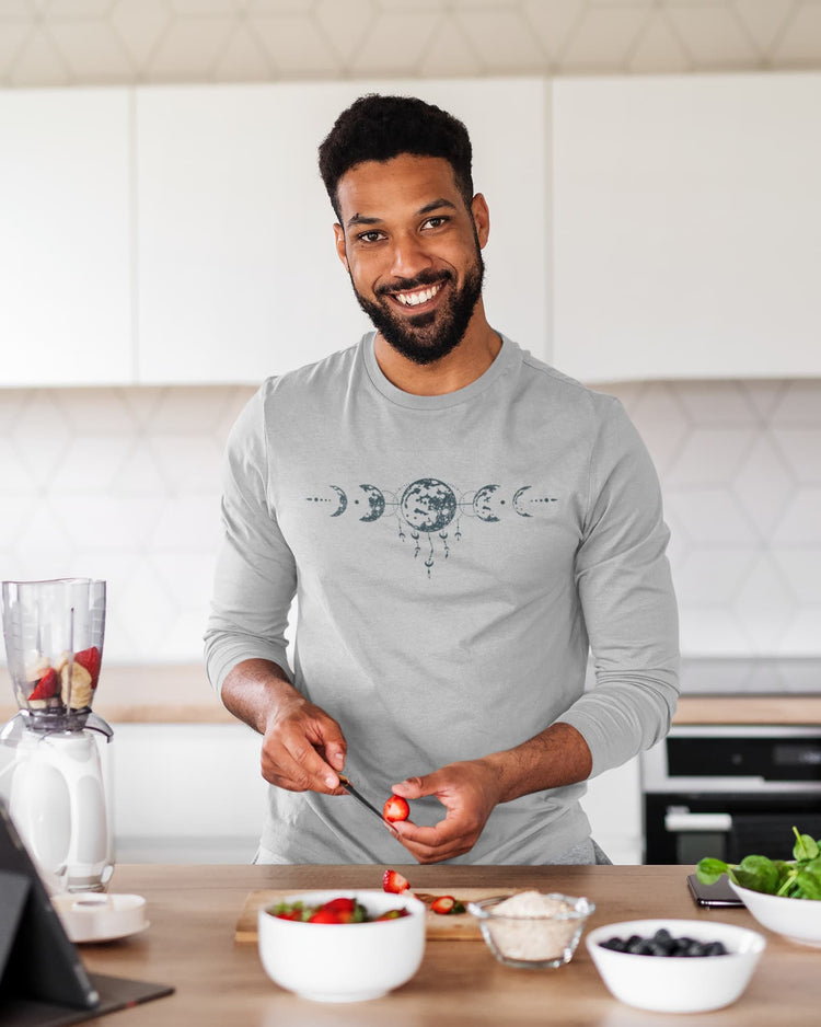 Man preparing food in a kitchen wearing a gray shirt with a design.