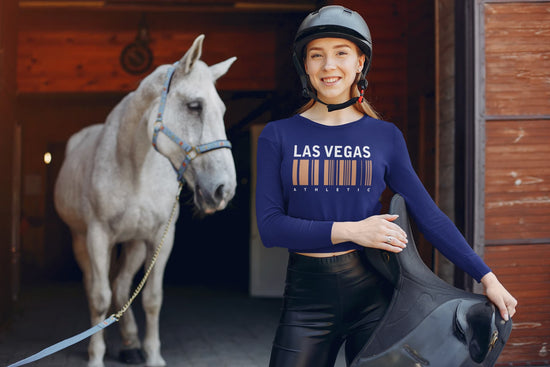 Woman in equestrian gear with a horse in a stable