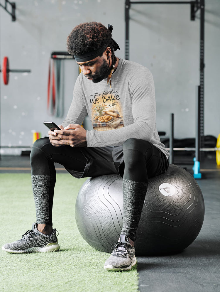 Person sitting on a stability ball in a gym setting, using a phone.