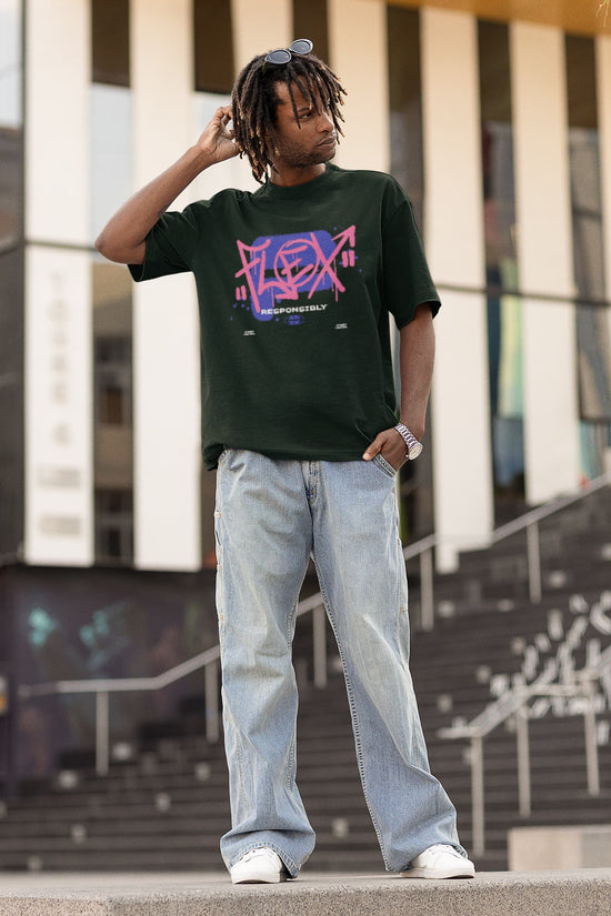Person wearing a GREEN t-shirt with colorful graphics and light blue jeans standing outdoors.