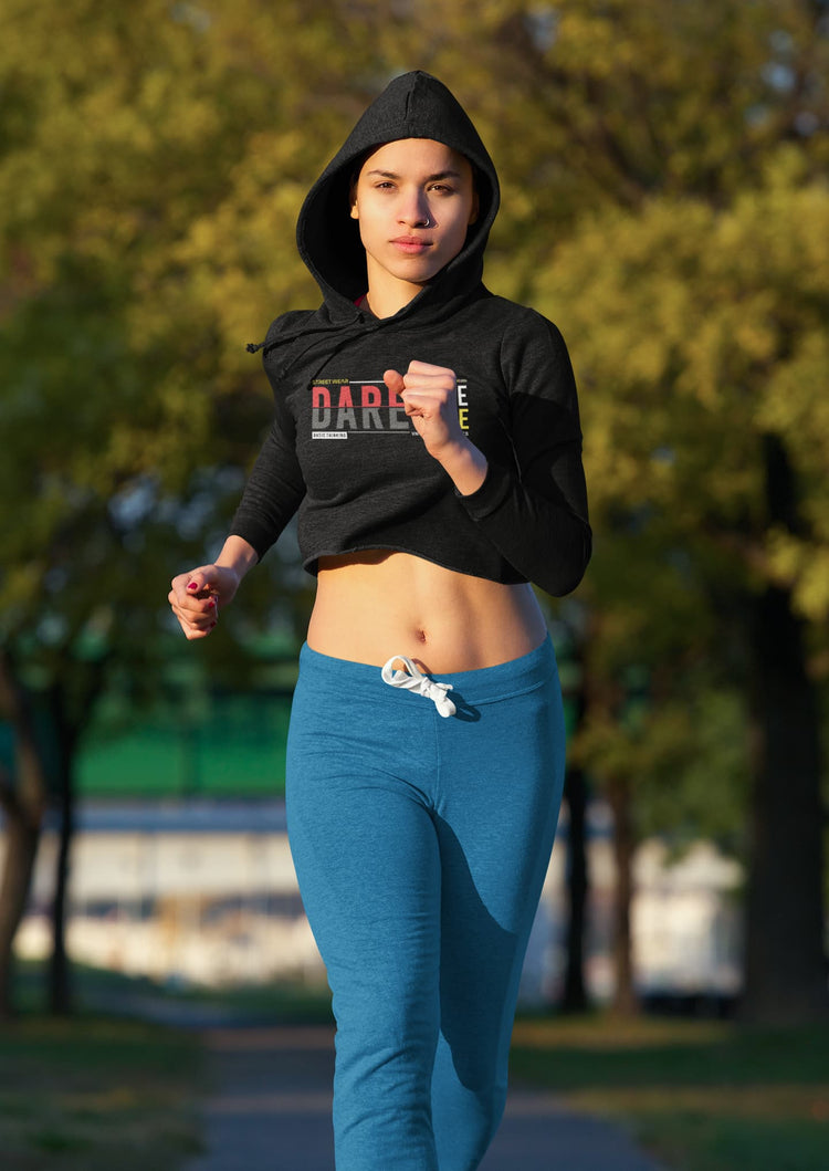 Person running outdoors wearing a black hoodie with visible branding and blue leggings.