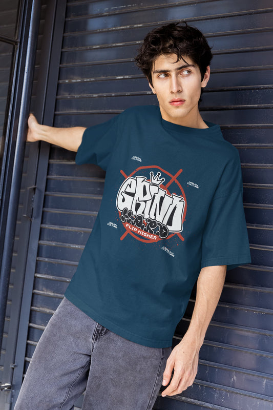 Person wearing a blue t-shirt with a graphic design against a metallic background