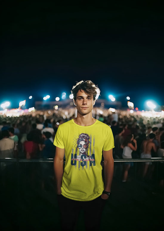 Person wearing a bright yellow t-shirt with a graphic design at a nighttime event.