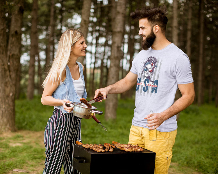 Man and woman grilling outdoors in a forest setting