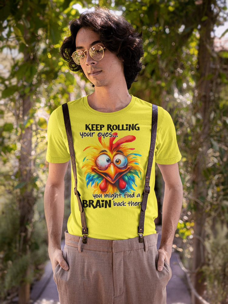 Person wearing a bright yellow t-shirt with a colorful rooster graphic and text, standing outdoors.