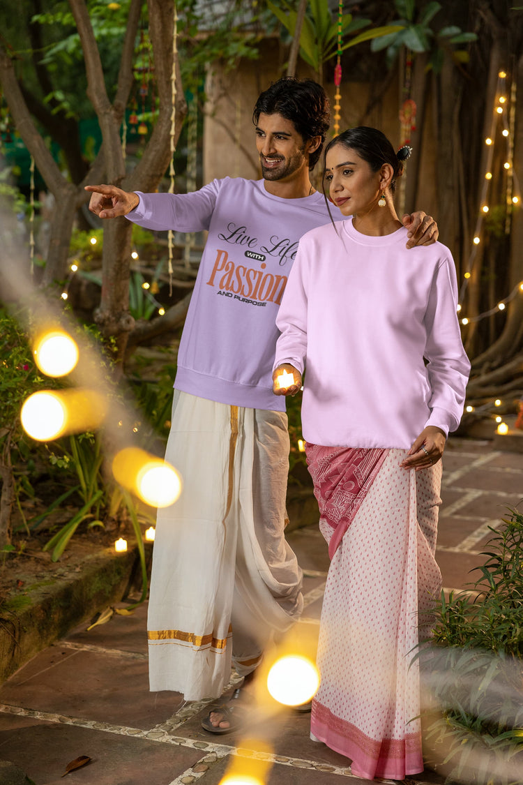 Man and woman in traditional attire standing together with string lights in the background