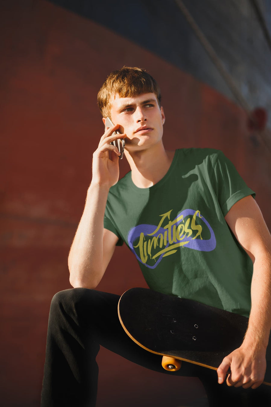 Person wearing a green t-shirt with a logo, holding a skateboard, against a blurred background