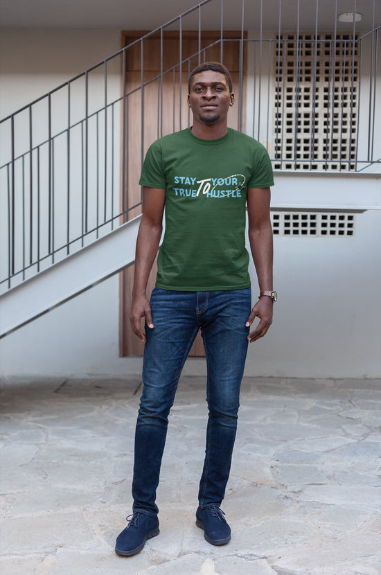 Man wearing a green t-shirt with text standing outdoors.