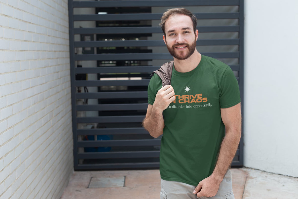Man wearing a green t-shirt with a logo and text, standing against a brick wall.