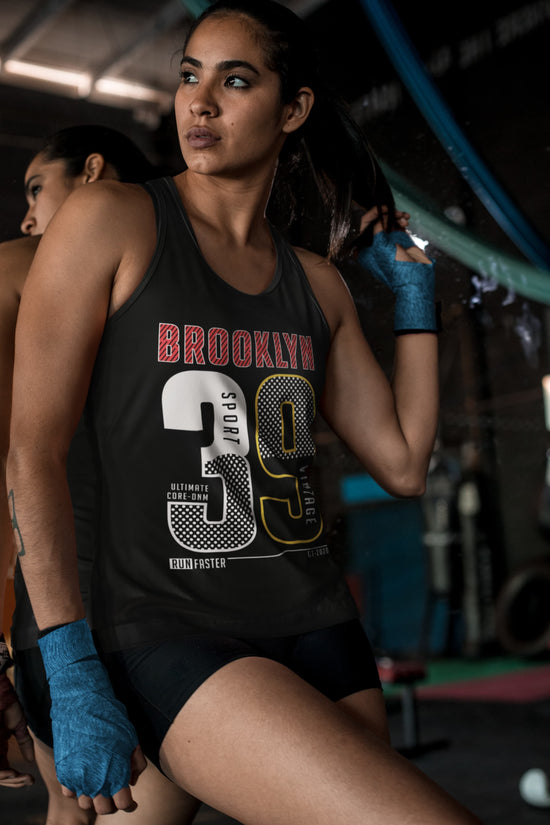 Woman in a gym wearing a black tank top with &