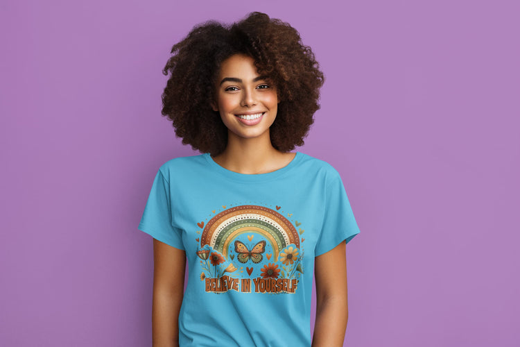 Woman wearing a blue t-shirt with a rainbow and butterfly design on a purple background