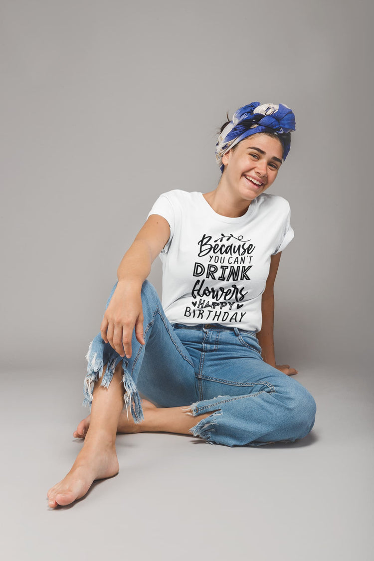 Woman wearing a white t-shirt with text and blue jeans sitting on a gray background