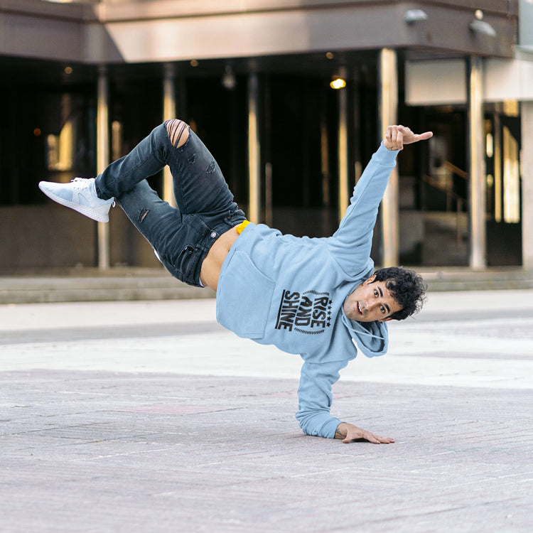 Person in a blue hoodie and jeans performing a handstand on a city street.