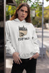 Person wearing a white hoodie with a skull and forest design, standing outdoors.