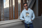 Man wearing a light blue hoodie with &