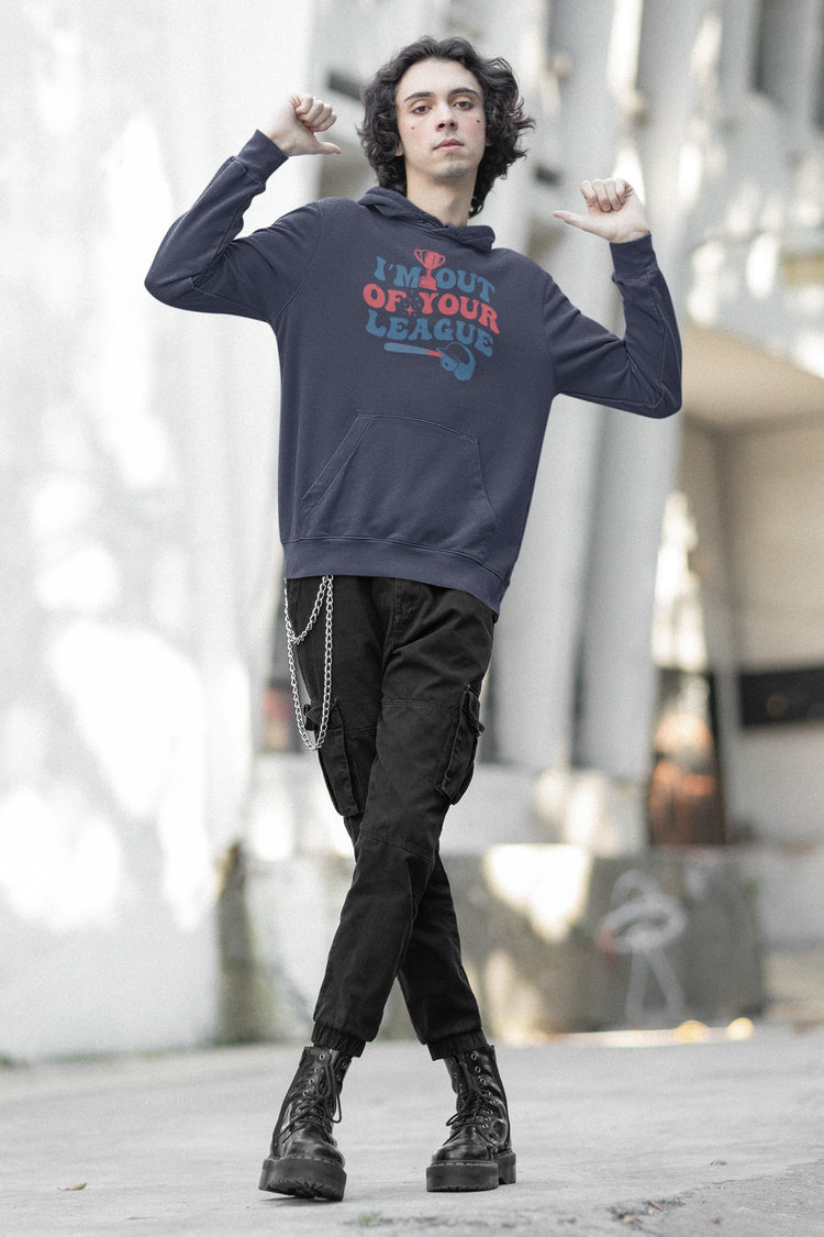 Person wearing a navy hoodie with text, black pants, and black boots on a blurred urban background
