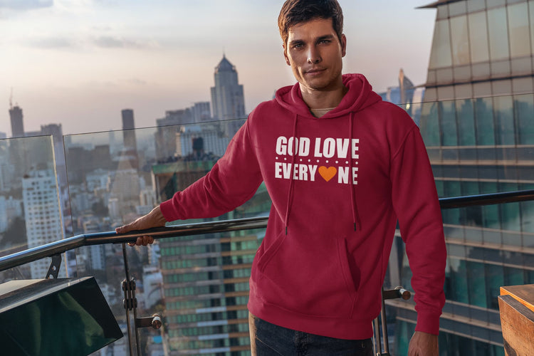 Man wearing a red hoodie with text, standing on a rooftop with cityscape in the background