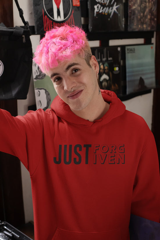 Person wearing a red hoodie with text, standing in a room with posters on the wall.