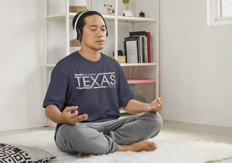 Man meditating with headphones on, wearing a &
