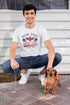 Man sitting on steps with a dachshund wearing a &