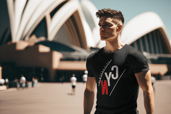 Man wearing a black t-shirt with a logo in front of the Sydney Opera House.