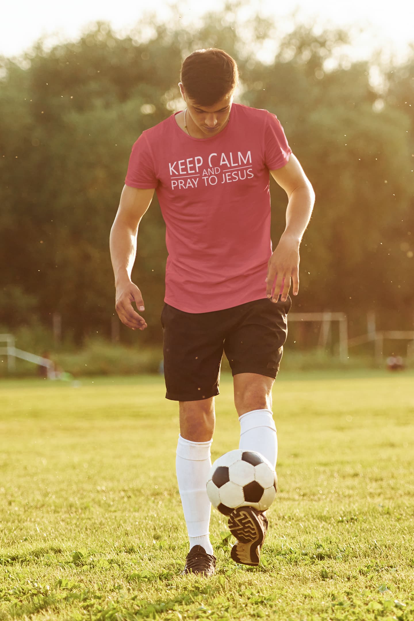 Man in pink shirt with text on a soccer field