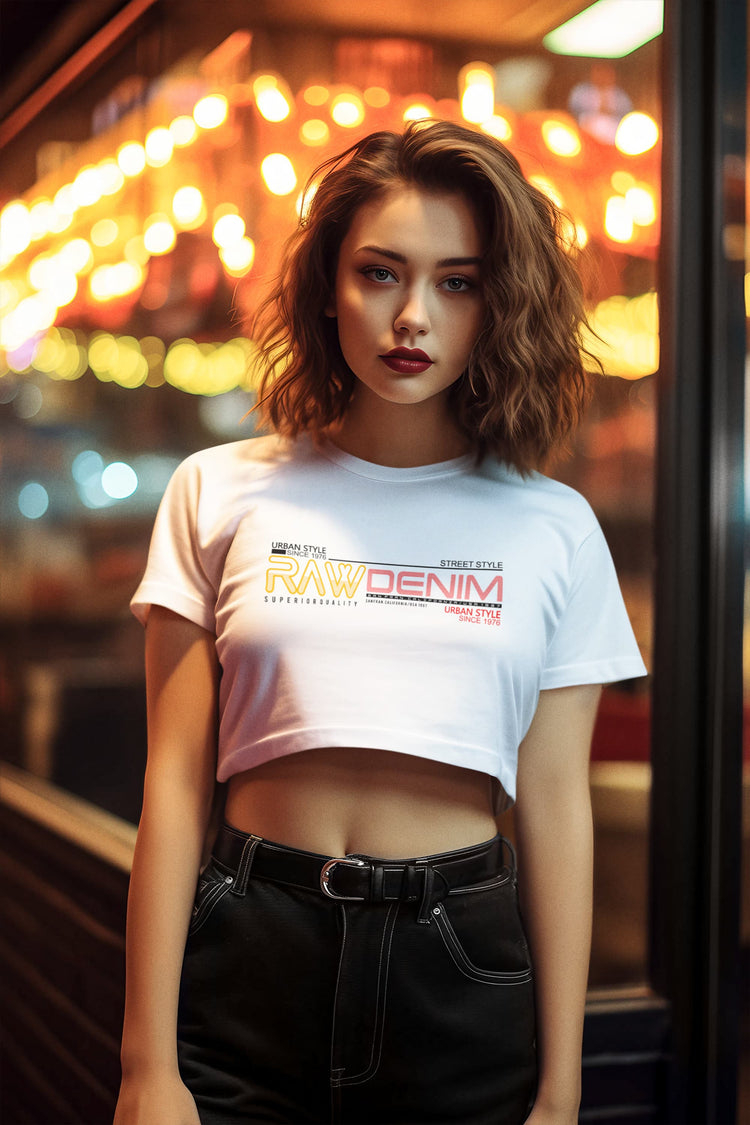 Woman wearing a white t-shirt with text and graphics, standing in a blurred indoor setting with lights.