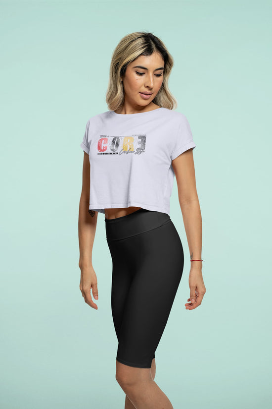 Woman wearing a white t-shirt with colorful text and black leggings on a light green background