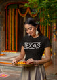 Woman holding a tray of food in a decorated outdoor setting