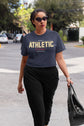 Woman walking outdoors wearing a dark blue t-shirt with &