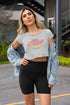 Woman wearing a gray crop top with &
